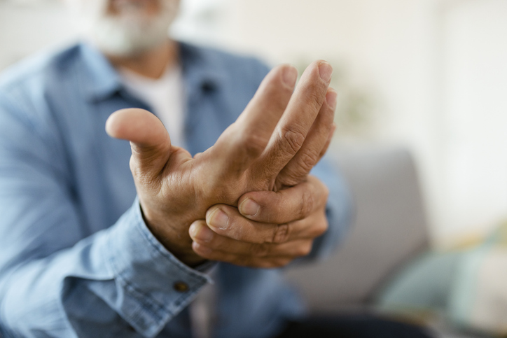 Man experiencing severe arthritis rheumatics pains, massaging, warming up arm.