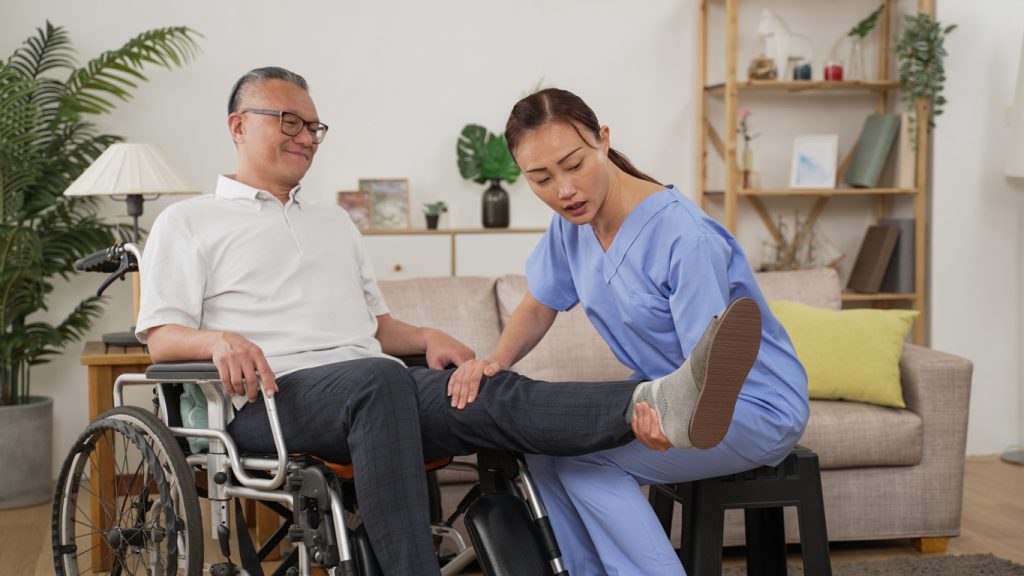 Nurse assisting a male senior with issues with his leg