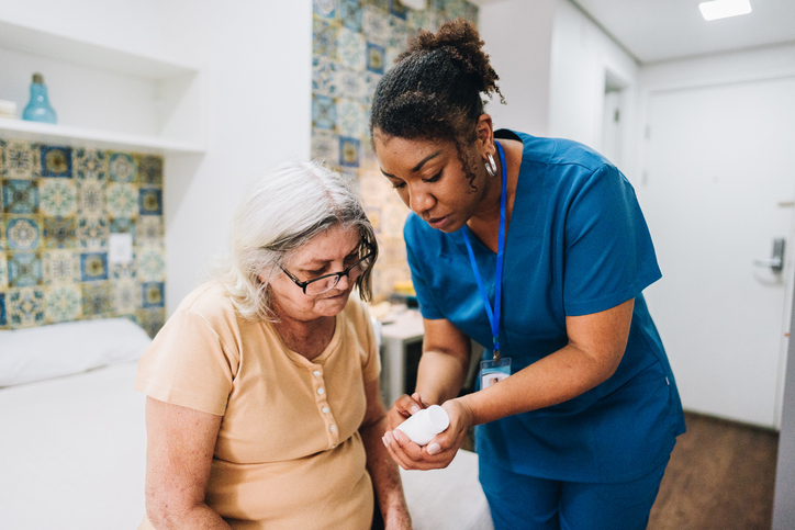 Nurse explaining to senior woman how to take her medicine at home.